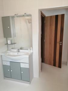 baño con lavabo, espejo y puerta en Casa Mimosa, en São Brás de Alportel