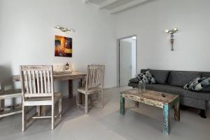 salon z kanapą, stołem i krzesłami w obiekcie Hofi Celia w mieście Blue Bay