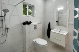 biała łazienka z toaletą i umywalką w obiekcie Hofi Celia w mieście Blue Bay +15 zdjęć