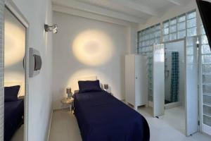 sypialnia z łóżkiem z niebieskim kocem w obiekcie Hofi Celia w mieście Blue Bay