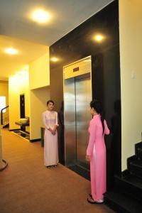 un hombre y una mujer de pie en un ascensor en Than Thien - Friendly Hotel en Hue
