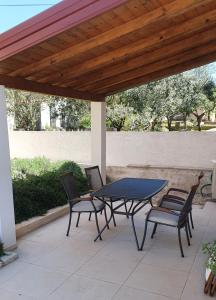 patio ze stołem i krzesłami pod drewnianym dachem w obiekcie Vacation home Villa Santa Eufemia w mieście Sutomišćica