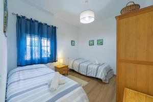 タリファにあるApto tranquilo en casco antiguoの青いカーテンが備わる客室のベッド2台