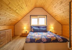 een slaapkamer met een bed in een houten hut bij Jaśkowe Wzgórze domki na wynajem Szymbark, balia, Domek nr 2 i 3 in Szymbark