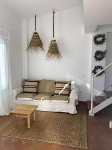 Apartamento en primera línea de playa في إل رومبيدو: غرفة معيشة مع أريكة بيضاء وطاولة