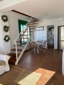 - un salon avec un escalier, une table et des chaises dans l'établissement Apartamento en primera línea de playa, à El Rompido