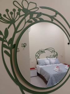 1 dormitorio con espejo grande y cama en Dimora Lazzarella, en Nápoles