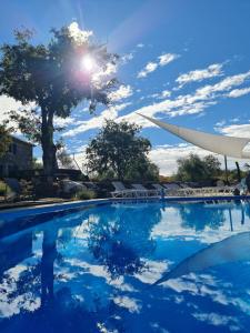 una piscina con el sol reflejándose en el agua en Boutique Resort OSMA, en Malinska