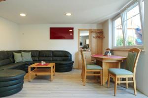 a living room with a couch and a table and chairs at URIA Ferienwohnung in Ostdorf