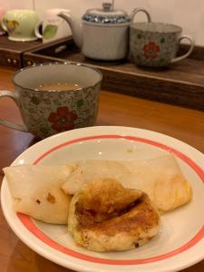 talerz jedzenia na stole z filiżanką herbaty w obiekcie Rimin Hostel w mieście Nanxi