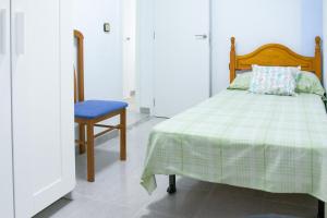 バレンシアにあるApartamento Privado Próximo a Playa y Cienciasのベッドルーム1室(ベッド1台、青い椅子付)