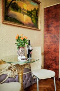 a table with a vase of flowers and a bottle of wine at ezio in Chişinău