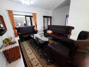 a living room with two leather couches and a table at Villa Bukit Nirwana in Bogor