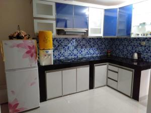 cocina con armarios blancos y nevera en Villa Bukit Nirwana, en Bogor