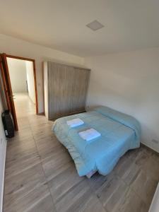 1 dormitorio con 1 cama con 2 toallas en departamento temporario en Esquel