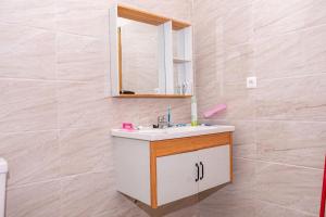 a bathroom with a sink and a mirror at Cheerful 4-bedroom home with parking in Bujumbura