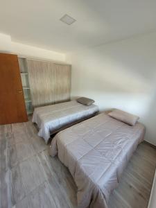 two beds sitting next to each other in a room at departamento temporario in Esquel
