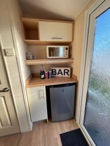 a kitchen with a bar in a tiny house at Mawson Retreat Dog Friendly Static Caravan in Millom
