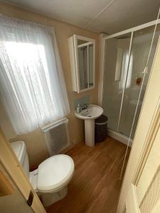 a small bathroom with a toilet and a sink at Mawson Retreat Dog Friendly Static Caravan in Millom