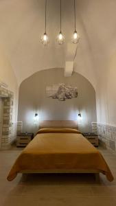 una camera da letto con un grande letto giallo con luci di Dimora Vesuviana a Ercolano