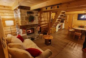 a living room with a couch and a fireplace at Koliba 30svibnja in Perušić