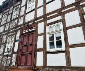une porte rouge sur le côté du bâtiment dans l'établissement Apartments Dombergblick - Suhl, Stadtmitte, à Suhl