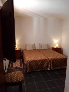 a bedroom with two beds and a tv in it at Quarto pequeno 515 do Monte dos Arneiros in Lavre