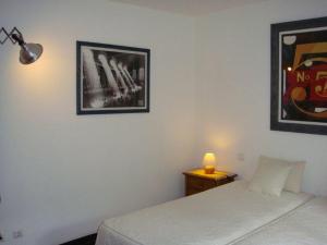 a bedroom with a bed and a table with a lamp at Quarto pequeno 515 do Monte dos Arneiros in Lavre