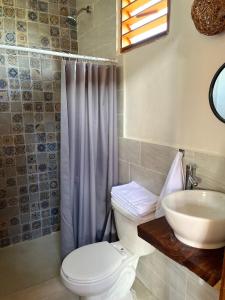 y baño con aseo y lavamanos. en Anicca Aldea en Holbox Island