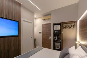 Schlafzimmer mit einem Bett und einem Flachbild-TV in der Unterkunft Aiello Hotels - Duomo in Mailand