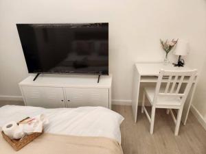 una camera da letto con una grande TV a schermo piatto e una scrivania di Studio in Azure with Arayat View a San Fernando