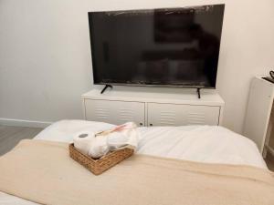 uma cama com um cesto de papel higiénico e uma televisão em Studio in Azure with Arayat View em San Fernando