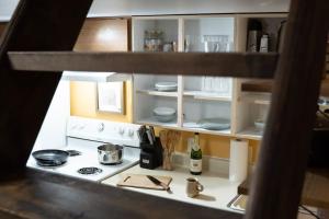 cocina con fogones y estante con platos en Cozy Studio Apartment With Sauna, en Fairbanks