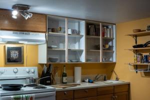 cocina con armarios blancos y fogones en Cozy Studio Apartment With Sauna, en Fairbanks