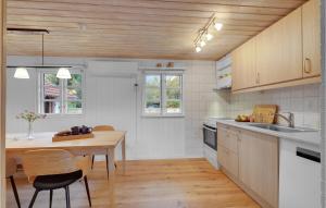 ヘアニングにあるGorgeous Home In Herning With Wifiの木製の天井、テーブル付きのキッチンが備わります。