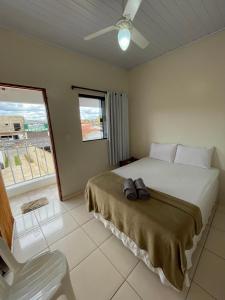 a bedroom with a bed and a chair and a window at Pouso Dona Ana in Pirenópolis