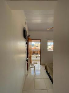 a hallway with a chair and a bed in a room at Pouso Dona Ana in Pirenópolis