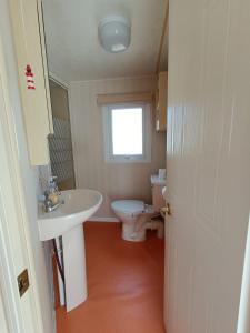 ein Bad mit einem Waschbecken und einem WC in der Unterkunft Pet friendly Holiday Caravan sleeps 5 in Hemsby