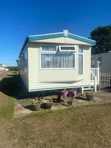 ein winziges Haus auf einem Wohnwagen im Hof in der Unterkunft Pet friendly Holiday Caravan sleeps 5 in Hemsby