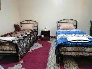 dos camas sentadas una al lado de la otra en una habitación en Takad Dream Rural, en El Borj