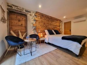 sypialnia z dużym łóżkiem i ceglaną ścianą w obiekcie La Voûte du Pilat & options SPA, massage w mieście Saint-Chamond +25 zdjęć