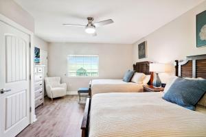 a bedroom with two beds and a chair at Harbourside 7718- Premier in Clearwater Beach