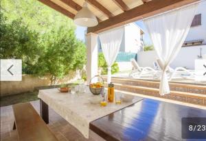 un tavolo con un cesto di frutta su un patio di Villa Palomita Con Piscina Privada a Son Serra de Marina