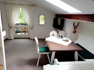 a dining room with a table and a television at Landhaus Bellecôte in Reit im Winkl