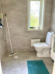 uma casa de banho com um WC branco e uma janela em Lilla Hule - på landet nära sjö em Oskarshamn