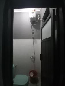 a small bathroom with a toilet and a light at Ganjar Homestay in Sentool