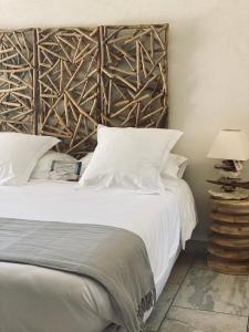 a bedroom with a white bed with a wooden headboard at Casa Legna in Pigna