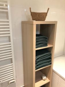 a shelf with towels and a basket in a bathroom at Le Lioran, La Sumène, Studio balcon tout confort aux pieds des pistes in Laveissière