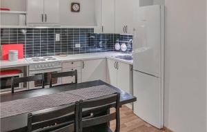 a kitchen with a table and a white refrigerator at Beautiful Apartment In Norheimsund With Wifi in Norheimsund