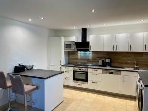 a kitchen with white cabinets and a counter top at Chalet an der Donau direkt bei Regensburg, 5 Sterne DTV in Pentling